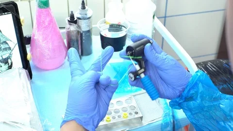 Safe tattooing. Preparing the tattoo machine for a session. 動画素材 73429749