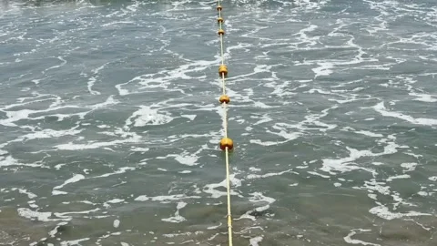 Safety Buoy Line in Rough Surf Waves. Rip current Beach Swimming Restriction Stock Footage 342782424