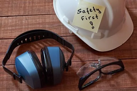 Safety first note one yellow piece of paper stuck on wooden background with f Stock Photos