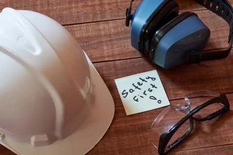 Safety first note one yellow piece of paper stuck on wooden background with f Stock Photos