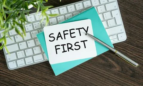 SAFETY FIRST text on paper on notebook with pen and table on keyboard and b.. Foto stock