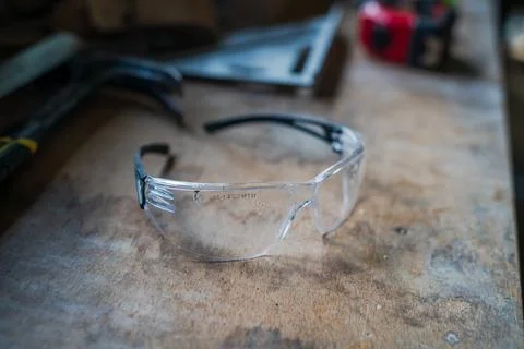 Safety glasses on workbench in carpentry workshop 库存照片