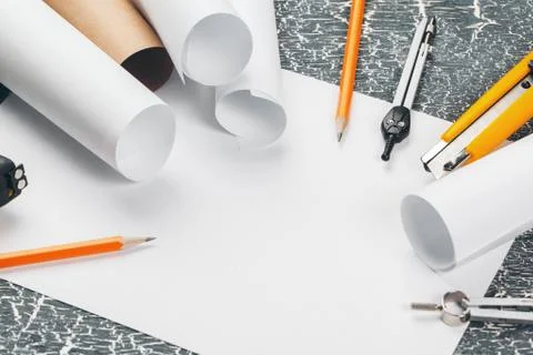 Safety helmet and Scrolls of engineering drawings and supplies Stock Photos