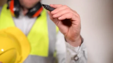 Safety officer writes work place hazards on a clear screen Stock Footage 79883764