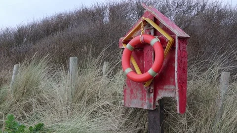 Safety ringbouy at the beach with long grass Stock Footage 169592723