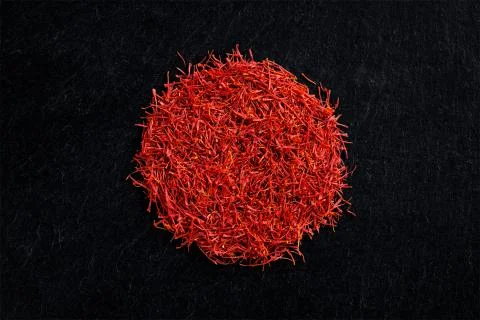 Saffron crocus threads on black slate background Stock Photos