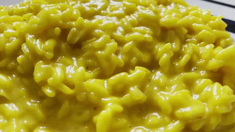 Saffron risotto on turning table - Macro spin of traditional Italian rice Видео 327568720