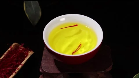 Saffron Tea Drop Falling into Teacup in Slow Motion on Dark Background Stock Footage 339642206