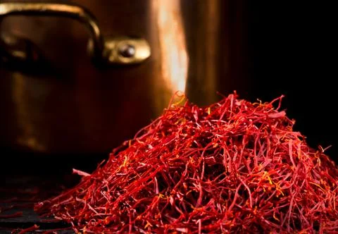 Saffron threads with copper pot and dark background Stock Photos