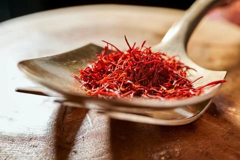 Saffron threads on a copper spoon close-up Stock Photos