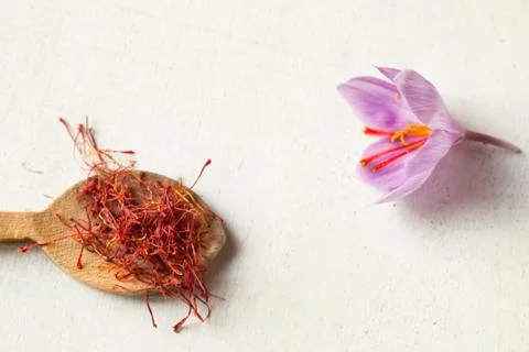 Saffron types in a spoon and saffron flower on a white background Stock Photos