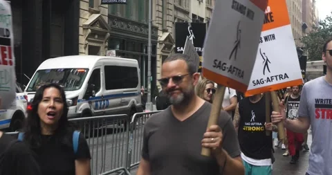 SAG-AFTRA Protesters March with Picket Signs Barricaded in Next to NYPD Stock Footage 246171024