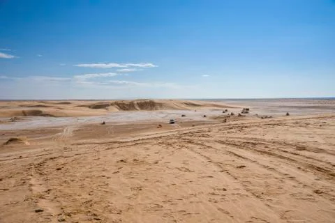 Sahara desert, with a salt marsh plot, with sand dunes, traces of past cars, and Stock Photos