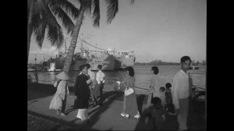 SAIGON - 1957: Harbor assembly - Dockside group gathers near moored boats Stock Footage 344502073