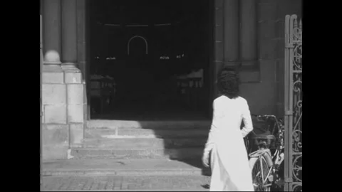SAIGON - 1957: Quiet arrival - Woman in white climbs church steps Stock Footage 344502053