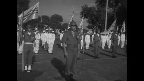 SAIGON - 1957: Service column - Helmeted flag detail marches in cadence Stock Footage 344502165