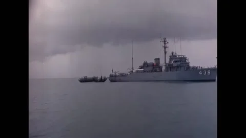 SAIGON - 1965 - A command junk sails toward the USS Excel off the coast of Stock Footage 312791688