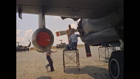 SAIGON - 1965 - Workers stand on a ladder and work on the engine of a P-2 Stock Footage 312793024
