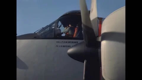SAIGON - 1966 - A pilot revving aircraft engine on cockpit. Two crewmen standing Stock Footage 312791035