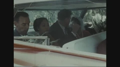 SAIGON - 1969: Wedding car - Wedding party seated in an open red convertible Stock Footage 343937179