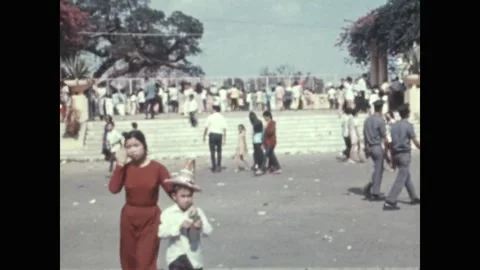 SAIGON - 1971: City park crowds - Park steps above a lake of rowing boats Stock Footage 343938324