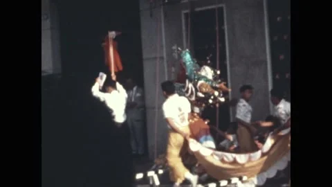 SAIGON - 1971: Dragon dance - A teal and gold dragon head worked on poles 库存影片 343938477