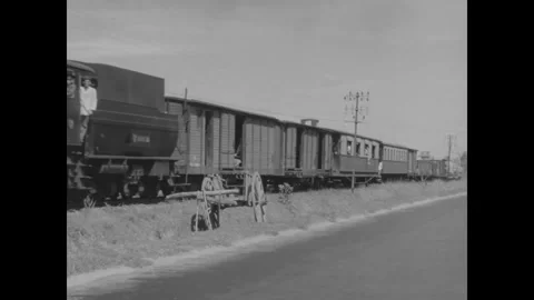 SAIGON, VIETNAM - 1957: Trackside rake - A steam train stands by the road Stock Footage 344004247