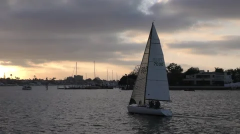 Sail boat sailing into the sunset on cloudy late afternoon harbor race.mp4 Stock Footage 67480165