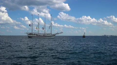 Sail boat with sails down across wavy moving ocean. 動画素材 136964322