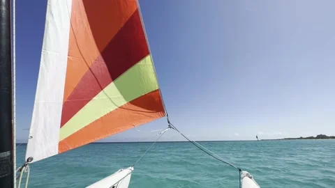 The sail of a small boat develops in the wind rushing to the horizon in the Video stock 238895405