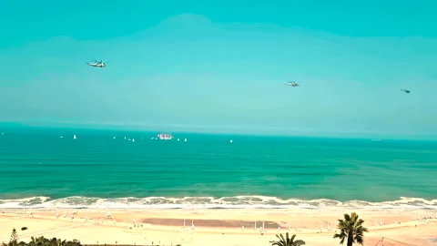 Sail Training Ship "Unión" with escort and 3 helicopters flying along the coast Stock Footage 277076748