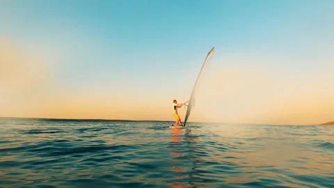 Sailboarder is navigating a windsurf board through the water Video stock 137387218