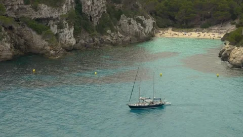 Sailboat in a Cala Macarella during a windy day, Minorca, Balearic Islands Видео 303752623