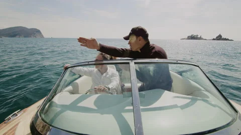 Sailboat captain shows navigation point to adult couple during cruise motor boat Stock Footage 152297748