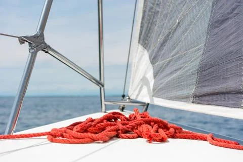 Sailboat deck with stacked red rope while sailing. Stock Photos