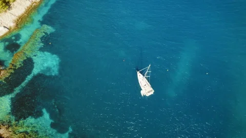 Sailboat floating above deep blue sea near coral formations in summer Kefalonia Stock Footage 311963291
