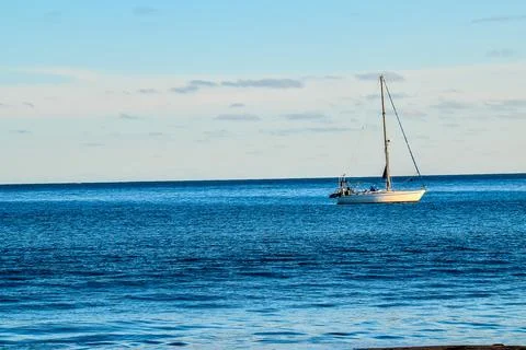 A sailboat is floating on the ocean Stock Photos