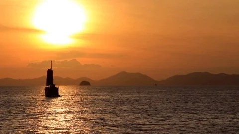 Sailboat is floating on the sea, as the sun sets on the horizon Stock Footage 98682905