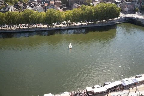 Sailboat glides gently down calm river waters Stock Photos