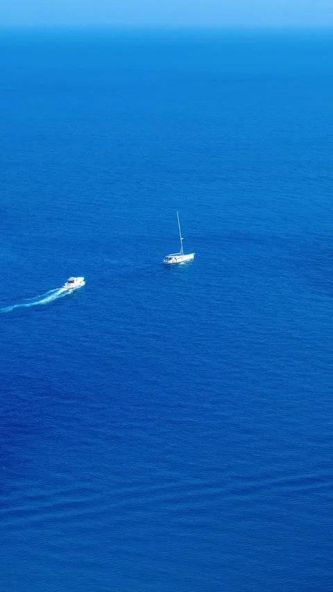 Sailboat Gliding Across Deep Blue Ocean Waters Under Clear Skies in the Stock Footage 334854994