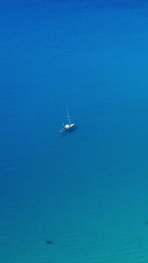 Sailboat Gliding Smoothly Over Crystal Blue Waters in a Serene Coastal Setting Stock Footage 311111598