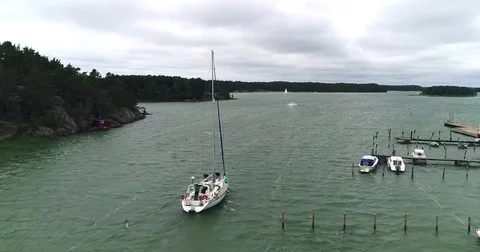 Sailboat leaving a harbor, Cinema 4k aerial view bypassing a sailboat, exitin Stock Footage