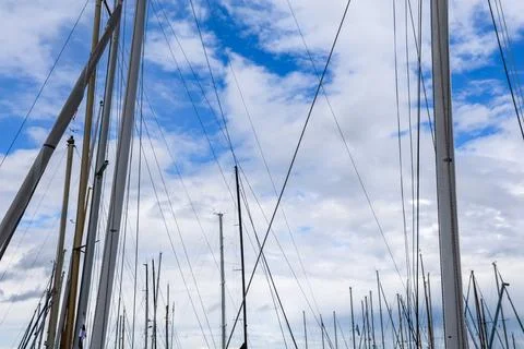 Sailboat masts and rigging creating geometric patterns against sky Stock Photos
