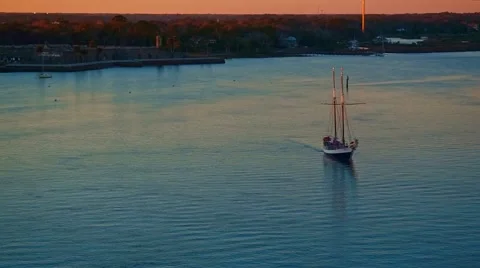 Sailboat with passengers sailing by city bay on a river  at sunset 스톡 동영상 61237341