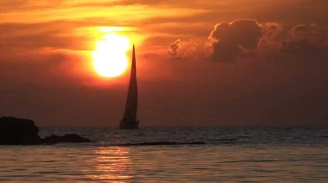 Sailboat passes in front of sun during sunset Stock Footage 8975125