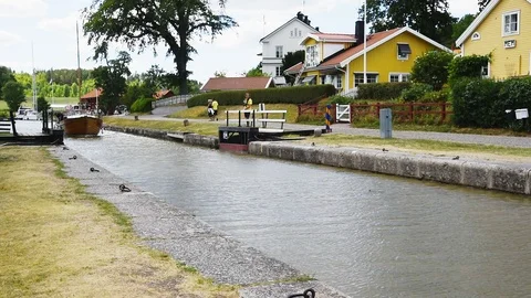 Sailboat passing open sluice gate Stock Footage 94507911