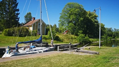 Sailboat passing sluice gate Stock Footage 96152992