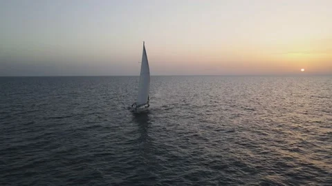 Sailboat sailing alone at sunset Stock Footage 167701821