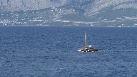 The sailboat sails the sea breaking the waves in the summer time Video stock 113997455