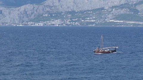 The sailboat sails the sea breaking the waves in the summer time Stock Footage 113998655